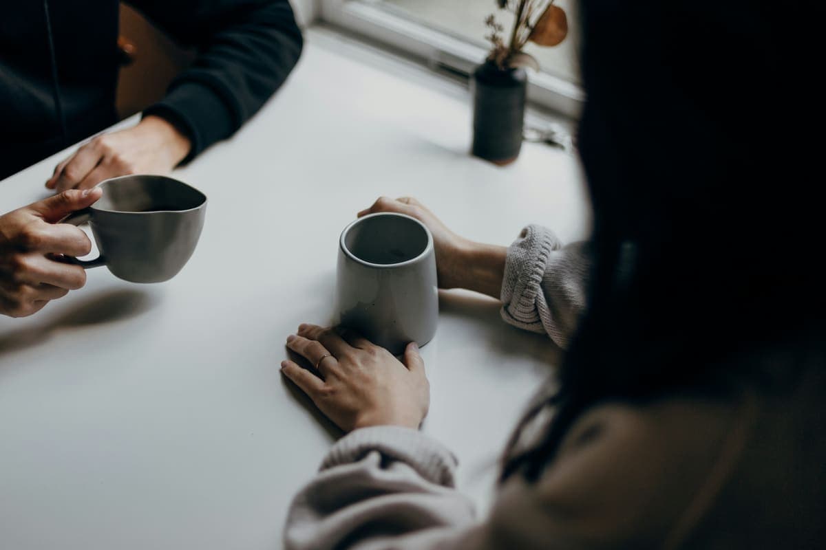 二人がコーヒーを挟んで対話する手元